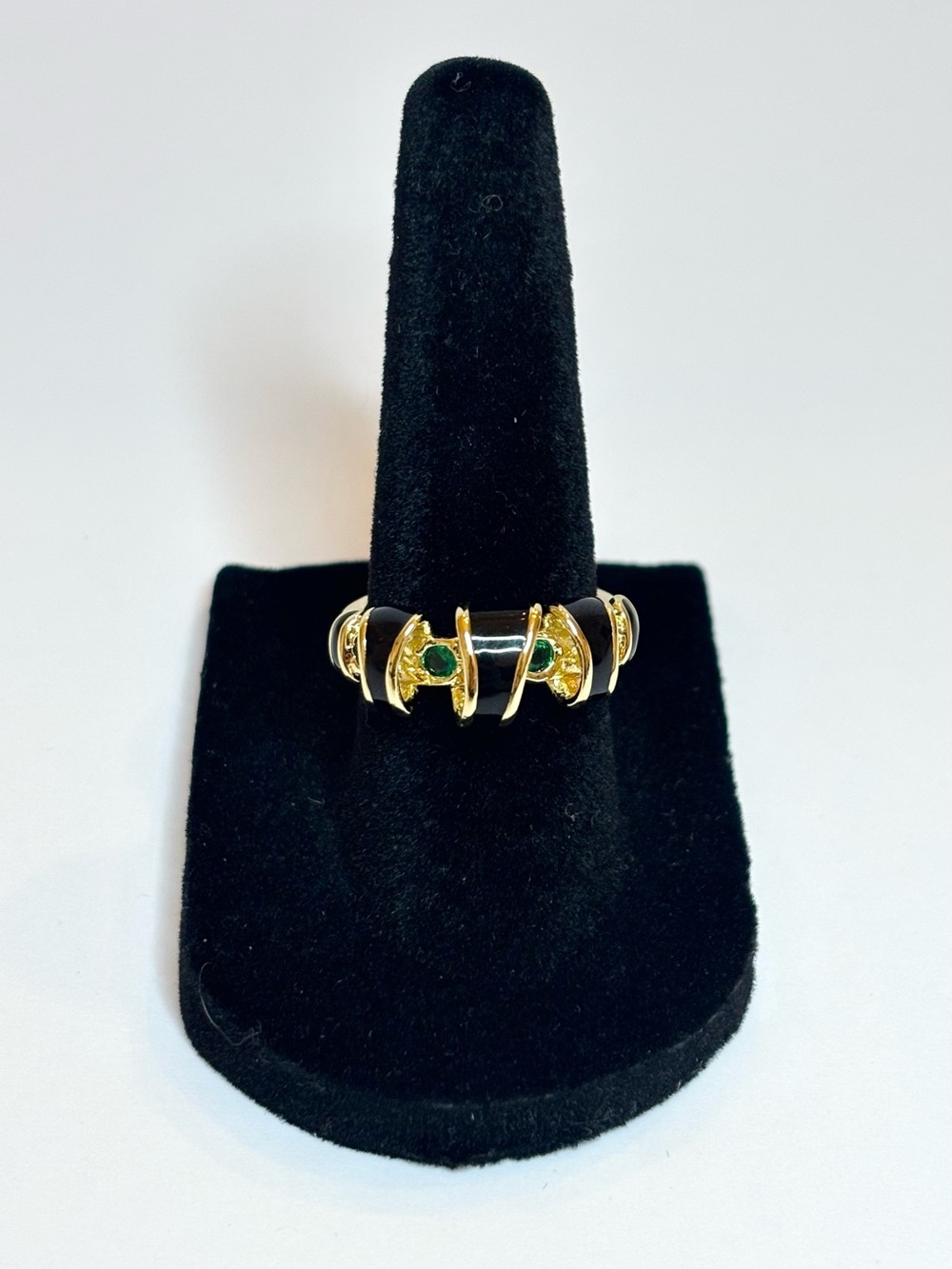 Gold spiral ring with black enamel and green stones